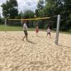 Umweltreferent Reiner Erben war beim ersten Aufschlag auf dem neuen Beachvolleyballfeld im Schillpark mit dabei. Die Kinder Lilly und Ole freuten sich, dass sie mitspielen durften