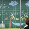 Eine Lehrerin schreibt «Schöne Sommerferien» an die Tafel einer Grundschulklasse. (Archivfoto)