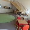 Blick in den Gruppenraum des Kindergartens. Über eine Treppe geht es hoch zu einer Galerie. Dort gibt es noch mehr Platz zum Spielen.