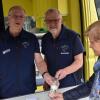 Der ehrenamtliche Mitarbeiter Georg Stüker (rechts) und Harald Gülzow (Mitte) nehmen eine Brunnenwasserprobe entgegen.