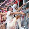 Thomas Müller steigt nach dem Bayern-Sieg auf den Zaun zu den Fans.