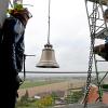 2,3 Tonnen wiegt die Glocke im Foto, die über das Loch im Turm Richtung Glockenstuhl schwebt. 