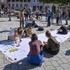 Unterstützerinnen und Unterstützer malten am Hauptplatz in Landsberg Botschaften mit Acrylfarbe auf ein Banner. 