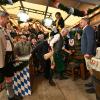 Dieter Reiter (SPD, Dritter von rechts), Oberbürgermeister von München, steht neben Markus Söder (CSU, links), Ministerpräsident von Bayern, und sticht das erste Oktoberfestfass im Schottenhammel-Festzelt an.