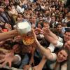 Oktoberfestbesucher versuchen nach dem Anzapfen im Paulaner-Festzelt ein Freibier zu ergattern. 