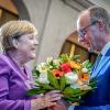 Friedrich Merz überreicht Angela Merkel zum 70. Geburtstag einen Blumenstrauß.