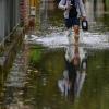 Ein Anwohner einer überfluteten Straße in Frankfurt Oder watet durch das Wasser.