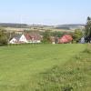 Am südlichen Ortsrand – hoch über dem Dorfkern – plant die Gemeinde ein Baugebiet in Gansheim. Links im Bild die Kirchturmspitze, im Hintergrund das zwischen Burgmannshofen und Ammerfeld errichtete Windrad.   