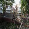 Ein Autowrack ist nach einem Angriff vor einem beschädigten Wohnhaus zu sehen.