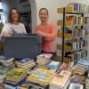 Viel Arbeit und trotzdem gute Laune: Christiane Karl (links) und Susanne Prömmel vor den „aussortierten“ Bücherbergen.