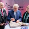 Bundespräsident Frank-Walter Steinmeier (m) trägt sich in das Goldene Buch der Stadt Kelkheim ein.