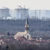 Der Kirchturm der katholischen Kirche St. Peter und Paul in Deutschland steht vor dem Atomkraftwerk Fessenheim in Frankreich. 