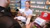 Die Pharmazeutisch-technische Assistentin (PTA) Sabrina Haggenmüller zeigt einem Kunden der Alpin Apotheke in Kempten verschiedene Mundschutz-Modelle. Die Nachfrage ist wegen der Berichterstattung über den neuartigen Corona-Virus „überdimensional“, sagt Chef Michael Bentz.