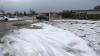 Der Parkplatz eines Supermarktes ist mit Hagel bedeckt.