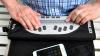 Ein Mann Arbeitet mit einer Braillezeile und einem Smartphone mit Kopfhörern. Die Braillezeile ist ein Ausgabegerät für Blinde, welches Texte in Brailleschrift umwandelt und mit dem Tastsinn erfühlt werden können.