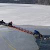 Einen Menschen, der ins Eis eingebrochen ist, soll man am besten mit einer langen Leiter aus dem Wasser ziehen. Das Bild zeigt eine Übung der Deutschen Lebens-Rettungs-Gesellschaft.