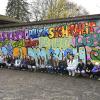 Die Rückwand der Wasserwachtgarage wurde von den 9. Klassen der Realschule Kaufering unter der Anleitung von Vincent Göhlich (rechts) mit Graffiti versehen. Von links sind Schulleiterin Annette Ring, Jugendpflegerin Constanze Knapp sowie Kunstlehrerin Sabrina Vongerichten mit den Jugendlichen zu sehen.