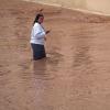 Eine Frau watet durch überflutete Straßen in Valencia.