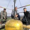 Von links: Vorarbeiter Tobias Schade, Kirchenpfleger Karl Böck und Pfarrer Michael Kinzl besichtigen die goldene Kugel auf dem Zwiebeldach der Kirche.