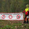 Michael Miller von der SVLFG zeigt die korrekte Absperrung eines Waldweges für Spaziergänger, Radfahrer und Reiter.