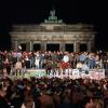 Jubelnde Menschen auf der Berliner Mauer am Brandenburger Tor am 10. November 1989. Am Abend zuvor waren die Grenzen geöffnet worden. 