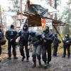 Ein Aktivist wird von Polizisten aus dem Protestcamp in der Nähe des Tesla-Autowerks in Grünheide abgeführt.