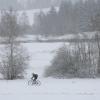 Ein Radfahrer fährt am 20. November 2024 durch die schneebedeckte Landschaft in Bayern.