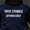 Ein Ermittler eines internationalen Forensik-Teams trägt eine Weste mit der Aufschrift „War Crimes Prosecutor“.