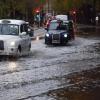 Taxis fahren über eine überschwemmte Straße in London.