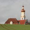 Die Biberbacher Wallfahrtskirche hat kein Gerüst mehr und präsentiert sich in neuem Glanz in diesem Bild oberhalb von Feldern.