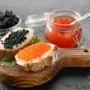 Sandwiches with delicious caviar on dark background