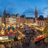 Die Lichter von Verkaufsbuden und Fahrgeschäften leuchten neben dem Weihnachtsbaum „Florian“ auf dem traditionellen Weihnachtsmarkt auf dem Römerberg in Frankfurt.