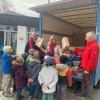 Einige Kinder der Kita und des Kindergartens Mering St. Afra verfolgen mit ihrer Leiterin Heidrun Rebitzer (Bildmitte) gespannt, wie sich die Päckchen mit Unterstützung des Humedica-Teams auf die Reise machen. 