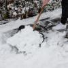 Mit einem Schneeschieber wird ein Gehweg von Schnee befreit. Winterlicher Schneefall und Temperaturen um den Gefrierpunkt sollen am zweiten Adventswochenende kommen.