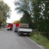 Um kurz nach 5 Uhr, am Tag der Deutschen Einheit, ist die Mindel in Jettingen (Landkreis Günzburg) übergelaufen und hat ein Wohngebiet überschwemmt. Offenbar war eine sogenannte Falle am Wasserkraftwerk defekt. Durch den starken Regen konnte nicht mehr genügend Wasser abfließen.

Wie Einsatzleiter und Kommandant der örtlichen Feuerwehr Markus Schmucker mitteilte, stand im "Korea", wie die Einheimischen das Wohngebiet am westlichen Ortsrand von Jettingen nennen, das Wasser auf den Straßen rund 20 Zentimeter hoch, als die Einsatzkräfte kamen. Und das Wasser stieg noch weiter.
Schleuse müssen geöffnet werdenAm ehemaligen Stauffenberg-Areal zwischen Mindellauf und Mindelkanal befindet sich ein Wasserkraftwerk mit zwei großen Fallen. Bei geringer ankommender Wassermenge sind beide Fallen geschlossen, um das Wasser komplett durch die Turbine zur Stromerzeugung zu leiten. Kommt aber eine so große Wassermenge von flussaufwärts an, dass das Wasser durch den alleinigen Durchfluss durch die Turbine nicht mehr abfließen kann, müssen die Fallen geöffnet werden, um ein Überlaufen der Mindel zu verhindern.Defekt an einer der SchleusenDie zweite Falle wird geöffnet, wenn notwendig. Wie der 2. Bürgermeister von Jettingen-Scheppach Hans Reichhardt berichtet, funktioniert diese zweite Falle seit geraumer Zeit allerdings nicht. Das Gestänge ist ausgehängt. Die Regenmengen am Montag waren so stark, dass das vom Oberlauf der Mindel ankommende Wasser nicht mehr genügend abgeleitet werden konnte. Das führte zum Ansteigen und schließlich zum Überlaufen der Mindel.Mindel läuft über!Das Wasser floss über mehrere Felder und überflutete schließlich das Wohngebiet bis zu einer Höhe von 1,20 Metern. Wie Reichhardt, der selbst ein Wasserkraftwerk betreibt, weiter ausführt, hatten Anwohner und die Gemeinde die Kraftwerksbetreiberin, die nicht im Landkreis wohnt, bereits dazu aufgefordert, die defekte Falle instand zu setzen. Dies sei leider bisher nicht geschehen, mit den nun entsprechenden Konsequenzen. Letztlich wurde ein von der Gemeinde betriebener Kanal geöffnet, über den eine große Wassermenge um das Wohngebiet herum abgeleitet werden kann.Große Schäden in PrivathäusernDie Familie Wolfmiller wohnt im Hammerschmiedweg und wurde vom Nachbarn gegen 6 Uhr angerufen und auf das Wasser aufmerksam gemacht. Wie der Vater sichtlich mitgenommen erklärt, hatte er dann mit einem Wassersauger im Keller das bereits dort angesammelte Wasser abgesaugt, als er plötzlich in einem Nebenraum ein Rauschen wahrnahm. Beim Nachschauen konnte er feststellen, dass dort die Bodenplatte des betonierten Kellers aufriss und das Wasser den Keller flutete. Neben Waschmaschine, Trockner und zwei Gefriertruhen ist auch der Speicher der Solaranlage im Keller. Alle Gerätschaften werden wohl komplett beschädigt worden sein.80 Kräfte im EinsatzZwischenzeitlich hatte der Einsatzleiter Schmucker u.a. noch die Feuerwehren Scheppach und Burgau nachalarmieren lassen. Insgesamt waren rund 80 Feuerwehrkräfte im Einsatz. Sie halfen mit rund 20 Tauch- und Tragkraftpumpen den Anwohnern beim vorsichtigen Auspumpen der Räumlichkeiten. Hier mussten die Einsatzkräfte aufpassen: Wenn der Wasserspiegel außen noch zu hoch ist, der Keller aber komplett leer gepumpt wird, wirkt ein großer Druck auf die Außenwände und die Bodenplatte eines Gebäudes. Das kann zu großen Schäden führen.Noch nie in diesem Ausmaß
Monika Wiesbauer, in deren Keller ebenfalls Wasser stand, zeigte ihren Garten. Dort hatte sie  noch am Sonntag Holz aufgestapelt und Blumen gerichtet. Nun steht dort das Wasser mehrere Zentimeter hoch. Die 68-Jährige wohnt dort seit 1958 und hat schon einige Male miterlebt, wie das Wasser aus dem Boden in den Keller gedrückt wurde. Dass es aber von oben in den Keller läuft und noch dazu in diesem Ausmaß, das gab es noch nie. Sie wurde gegen 6.30 Uhr von ihrem Nachbarn geweckt mit den Worten "Monika mach auf, da kommt 's Wasser." Doch viel dagegen tun konnte sie nicht. Hochwassergebiet ausgewiesenAuf die betroffenen Anwohner kommt eine schwere Zeit zu. Das Gebiet ist als Hochwassergebiet ausgewiesen. Daher ist es nicht möglich, ihre Häuser gegen solche Schäden zu versichern. Zudem müssen sie nun versuchen, die wassergetränkten Wände wieder trocken zu bekommen, was bei den aktuellen und weiter steigenden Energiekosten nochmals eine große Herausforderung darstellt. Ganz abgesehen von den beschädigten Gerätschaften und Heizungsanlagen.