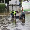 Um kurz nach 5 Uhr, am Tag der Deutschen Einheit, ist die Mindel in Jettingen (Landkreis Günzburg) übergelaufen und hat ein Wohngebiet überschwemmt. Offenbar war eine sogenannte Falle am Wasserkraftwerk defekt. Durch den starken Regen konnte nicht mehr genügend Wasser abfließen.

Wie Einsatzleiter und Kommandant der örtlichen Feuerwehr Markus Schmucker mitteilte, stand im "Korea", wie die Einheimischen das Wohngebiet am westlichen Ortsrand von Jettingen nennen, das Wasser auf den Straßen rund 20 Zentimeter hoch, als die Einsatzkräfte kamen. Und das Wasser stieg noch weiter.
Schleuse müssen geöffnet werdenAm ehemaligen Stauffenberg-Areal zwischen Mindellauf und Mindelkanal befindet sich ein Wasserkraftwerk mit zwei großen Fallen. Bei geringer ankommender Wassermenge sind beide Fallen geschlossen, um das Wasser komplett durch die Turbine zur Stromerzeugung zu leiten. Kommt aber eine so große Wassermenge von flussaufwärts an, dass das Wasser durch den alleinigen Durchfluss durch die Turbine nicht mehr abfließen kann, müssen die Fallen geöffnet werden, um ein Überlaufen der Mindel zu verhindern.Defekt an einer der SchleusenDie zweite Falle wird geöffnet, wenn notwendig. Wie der 2. Bürgermeister von Jettingen-Scheppach Hans Reichhardt berichtet, funktioniert diese zweite Falle seit geraumer Zeit allerdings nicht. Das Gestänge ist ausgehängt. Die Regenmengen am Montag waren so stark, dass das vom Oberlauf der Mindel ankommende Wasser nicht mehr genügend abgeleitet werden konnte. Das führte zum Ansteigen und schließlich zum Überlaufen der Mindel.Mindel läuft über!Das Wasser floss über mehrere Felder und überflutete schließlich das Wohngebiet bis zu einer Höhe von 1,20 Metern. Wie Reichhardt, der selbst ein Wasserkraftwerk betreibt, weiter ausführt, hatten Anwohner und die Gemeinde die Kraftwerksbetreiberin, die nicht im Landkreis wohnt, bereits dazu aufgefordert, die defekte Falle instand zu setzen. Dies sei leider bisher nicht geschehen, mit den nun entsprechenden Konsequenzen. Letztlich wurde ein von der Gemeinde betriebener Kanal geöffnet, über den eine große Wassermenge um das Wohngebiet herum abgeleitet werden kann.Große Schäden in PrivathäusernDie Familie Wolfmiller wohnt im Hammerschmiedweg und wurde vom Nachbarn gegen 6 Uhr angerufen und auf das Wasser aufmerksam gemacht. Wie der Vater sichtlich mitgenommen erklärt, hatte er dann mit einem Wassersauger im Keller das bereits dort angesammelte Wasser abgesaugt, als er plötzlich in einem Nebenraum ein Rauschen wahrnahm. Beim Nachschauen konnte er feststellen, dass dort die Bodenplatte des betonierten Kellers aufriss und das Wasser den Keller flutete. Neben Waschmaschine, Trockner und zwei Gefriertruhen ist auch der Speicher der Solaranlage im Keller. Alle Gerätschaften werden wohl komplett beschädigt worden sein.80 Kräfte im EinsatzZwischenzeitlich hatte der Einsatzleiter Schmucker u.a. noch die Feuerwehren Scheppach und Burgau nachalarmieren lassen. Insgesamt waren rund 80 Feuerwehrkräfte im Einsatz. Sie halfen mit rund 20 Tauch- und Tragkraftpumpen den Anwohnern beim vorsichtigen Auspumpen der Räumlichkeiten. Hier mussten die Einsatzkräfte aufpassen: Wenn der Wasserspiegel außen noch zu hoch ist, der Keller aber komplett leer gepumpt wird, wirkt ein großer Druck auf die Außenwände und die Bodenplatte eines Gebäudes. Das kann zu großen Schäden führen.Noch nie in diesem Ausmaß
Monika Wiesbauer, in deren Keller ebenfalls Wasser stand, zeigte ihren Garten. Dort hatte sie  noch am Sonntag Holz aufgestapelt und Blumen gerichtet. Nun steht dort das Wasser mehrere Zentimeter hoch. Die 68-Jährige wohnt dort seit 1958 und hat schon einige Male miterlebt, wie das Wasser aus dem Boden in den Keller gedrückt wurde. Dass es aber von oben in den Keller läuft und noch dazu in diesem Ausmaß, das gab es noch nie. Sie wurde gegen 6.30 Uhr von ihrem Nachbarn geweckt mit den Worten "Monika mach auf, da kommt 's Wasser." Doch viel dagegen tun konnte sie nicht. Hochwassergebiet ausgewiesenAuf die betroffenen Anwohner kommt eine schwere Zeit zu. Das Gebiet ist als Hochwassergebiet ausgewiesen. Daher ist es nicht möglich, ihre Häuser gegen solche Schäden zu versichern. Zudem müssen sie nun versuchen, die wassergetränkten Wände wieder trocken zu bekommen, was bei den aktuellen und weiter steigenden Energiekosten nochmals eine große Herausforderung darstellt. Ganz abgesehen von den beschädigten Gerätschaften und Heizungsanlagen.