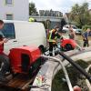 Um kurz nach 5 Uhr, am Tag der Deutschen Einheit, ist die Mindel in Jettingen (Landkreis Günzburg) übergelaufen und hat ein Wohngebiet überschwemmt. Offenbar war eine sogenannte Falle am Wasserkraftwerk defekt. Durch den starken Regen konnte nicht mehr genügend Wasser abfließen.

Wie Einsatzleiter und Kommandant der örtlichen Feuerwehr Markus Schmucker mitteilte, stand im "Korea", wie die Einheimischen das Wohngebiet am westlichen Ortsrand von Jettingen nennen, das Wasser auf den Straßen rund 20 Zentimeter hoch, als die Einsatzkräfte kamen. Und das Wasser stieg noch weiter.
Schleuse müssen geöffnet werdenAm ehemaligen Stauffenberg-Areal zwischen Mindellauf und Mindelkanal befindet sich ein Wasserkraftwerk mit zwei großen Fallen. Bei geringer ankommender Wassermenge sind beide Fallen geschlossen, um das Wasser komplett durch die Turbine zur Stromerzeugung zu leiten. Kommt aber eine so große Wassermenge von flussaufwärts an, dass das Wasser durch den alleinigen Durchfluss durch die Turbine nicht mehr abfließen kann, müssen die Fallen geöffnet werden, um ein Überlaufen der Mindel zu verhindern.Defekt an einer der SchleusenDie zweite Falle wird geöffnet, wenn notwendig. Wie der 2. Bürgermeister von Jettingen-Scheppach Hans Reichhardt berichtet, funktioniert diese zweite Falle seit geraumer Zeit allerdings nicht. Das Gestänge ist ausgehängt. Die Regenmengen am Montag waren so stark, dass das vom Oberlauf der Mindel ankommende Wasser nicht mehr genügend abgeleitet werden konnte. Das führte zum Ansteigen und schließlich zum Überlaufen der Mindel.Mindel läuft über!Das Wasser floss über mehrere Felder und überflutete schließlich das Wohngebiet bis zu einer Höhe von 1,20 Metern. Wie Reichhardt, der selbst ein Wasserkraftwerk betreibt, weiter ausführt, hatten Anwohner und die Gemeinde die Kraftwerksbetreiberin, die nicht im Landkreis wohnt, bereits dazu aufgefordert, die defekte Falle instand zu setzen. Dies sei leider bisher nicht geschehen, mit den nun entsprechenden Konsequenzen. Letztlich wurde ein von der Gemeinde betriebener Kanal geöffnet, über den eine große Wassermenge um das Wohngebiet herum abgeleitet werden kann.Große Schäden in PrivathäusernDie Familie Wolfmiller wohnt im Hammerschmiedweg und wurde vom Nachbarn gegen 6 Uhr angerufen und auf das Wasser aufmerksam gemacht. Wie der Vater sichtlich mitgenommen erklärt, hatte er dann mit einem Wassersauger im Keller das bereits dort angesammelte Wasser abgesaugt, als er plötzlich in einem Nebenraum ein Rauschen wahrnahm. Beim Nachschauen konnte er feststellen, dass dort die Bodenplatte des betonierten Kellers aufriss und das Wasser den Keller flutete. Neben Waschmaschine, Trockner und zwei Gefriertruhen ist auch der Speicher der Solaranlage im Keller. Alle Gerätschaften werden wohl komplett beschädigt worden sein.80 Kräfte im EinsatzZwischenzeitlich hatte der Einsatzleiter Schmucker u.a. noch die Feuerwehren Scheppach und Burgau nachalarmieren lassen. Insgesamt waren rund 80 Feuerwehrkräfte im Einsatz. Sie halfen mit rund 20 Tauch- und Tragkraftpumpen den Anwohnern beim vorsichtigen Auspumpen der Räumlichkeiten. Hier mussten die Einsatzkräfte aufpassen: Wenn der Wasserspiegel außen noch zu hoch ist, der Keller aber komplett leer gepumpt wird, wirkt ein großer Druck auf die Außenwände und die Bodenplatte eines Gebäudes. Das kann zu großen Schäden führen.Noch nie in diesem Ausmaß
Monika Wiesbauer, in deren Keller ebenfalls Wasser stand, zeigte ihren Garten. Dort hatte sie  noch am Sonntag Holz aufgestapelt und Blumen gerichtet. Nun steht dort das Wasser mehrere Zentimeter hoch. Die 68-Jährige wohnt dort seit 1958 und hat schon einige Male miterlebt, wie das Wasser aus dem Boden in den Keller gedrückt wurde. Dass es aber von oben in den Keller läuft und noch dazu in diesem Ausmaß, das gab es noch nie. Sie wurde gegen 6.30 Uhr von ihrem Nachbarn geweckt mit den Worten "Monika mach auf, da kommt 's Wasser." Doch viel dagegen tun konnte sie nicht. Hochwassergebiet ausgewiesenAuf die betroffenen Anwohner kommt eine schwere Zeit zu. Das Gebiet ist als Hochwassergebiet ausgewiesen. Daher ist es nicht möglich, ihre Häuser gegen solche Schäden zu versichern. Zudem müssen sie nun versuchen, die wassergetränkten Wände wieder trocken zu bekommen, was bei den aktuellen und weiter steigenden Energiekosten nochmals eine große Herausforderung darstellt. Ganz abgesehen von den beschädigten Gerätschaften und Heizungsanlagen.