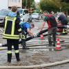 Um kurz nach 5 Uhr, am Tag der Deutschen Einheit, ist die Mindel in Jettingen (Landkreis Günzburg) übergelaufen und hat ein Wohngebiet überschwemmt. Offenbar war eine sogenannte Falle am Wasserkraftwerk defekt. Durch den starken Regen konnte nicht mehr genügend Wasser abfließen.

Wie Einsatzleiter und Kommandant der örtlichen Feuerwehr Markus Schmucker mitteilte, stand im "Korea", wie die Einheimischen das Wohngebiet am westlichen Ortsrand von Jettingen nennen, das Wasser auf den Straßen rund 20 Zentimeter hoch, als die Einsatzkräfte kamen. Und das Wasser stieg noch weiter.
Schleuse müssen geöffnet werdenAm ehemaligen Stauffenberg-Areal zwischen Mindellauf und Mindelkanal befindet sich ein Wasserkraftwerk mit zwei großen Fallen. Bei geringer ankommender Wassermenge sind beide Fallen geschlossen, um das Wasser komplett durch die Turbine zur Stromerzeugung zu leiten. Kommt aber eine so große Wassermenge von flussaufwärts an, dass das Wasser durch den alleinigen Durchfluss durch die Turbine nicht mehr abfließen kann, müssen die Fallen geöffnet werden, um ein Überlaufen der Mindel zu verhindern.Defekt an einer der SchleusenDie zweite Falle wird geöffnet, wenn notwendig. Wie der 2. Bürgermeister von Jettingen-Scheppach Hans Reichhardt berichtet, funktioniert diese zweite Falle seit geraumer Zeit allerdings nicht. Das Gestänge ist ausgehängt. Die Regenmengen am Montag waren so stark, dass das vom Oberlauf der Mindel ankommende Wasser nicht mehr genügend abgeleitet werden konnte. Das führte zum Ansteigen und schließlich zum Überlaufen der Mindel.Mindel läuft über!Das Wasser floss über mehrere Felder und überflutete schließlich das Wohngebiet bis zu einer Höhe von 1,20 Metern. Wie Reichhardt, der selbst ein Wasserkraftwerk betreibt, weiter ausführt, hatten Anwohner und die Gemeinde die Kraftwerksbetreiberin, die nicht im Landkreis wohnt, bereits dazu aufgefordert, die defekte Falle instand zu setzen. Dies sei leider bisher nicht geschehen, mit den nun entsprechenden Konsequenzen. Letztlich wurde ein von der Gemeinde betriebener Kanal geöffnet, über den eine große Wassermenge um das Wohngebiet herum abgeleitet werden kann.Große Schäden in PrivathäusernDie Familie Wolfmiller wohnt im Hammerschmiedweg und wurde vom Nachbarn gegen 6 Uhr angerufen und auf das Wasser aufmerksam gemacht. Wie der Vater sichtlich mitgenommen erklärt, hatte er dann mit einem Wassersauger im Keller das bereits dort angesammelte Wasser abgesaugt, als er plötzlich in einem Nebenraum ein Rauschen wahrnahm. Beim Nachschauen konnte er feststellen, dass dort die Bodenplatte des betonierten Kellers aufriss und das Wasser den Keller flutete. Neben Waschmaschine, Trockner und zwei Gefriertruhen ist auch der Speicher der Solaranlage im Keller. Alle Gerätschaften werden wohl komplett beschädigt worden sein.80 Kräfte im EinsatzZwischenzeitlich hatte der Einsatzleiter Schmucker u.a. noch die Feuerwehren Scheppach und Burgau nachalarmieren lassen. Insgesamt waren rund 80 Feuerwehrkräfte im Einsatz. Sie halfen mit rund 20 Tauch- und Tragkraftpumpen den Anwohnern beim vorsichtigen Auspumpen der Räumlichkeiten. Hier mussten die Einsatzkräfte aufpassen: Wenn der Wasserspiegel außen noch zu hoch ist, der Keller aber komplett leer gepumpt wird, wirkt ein großer Druck auf die Außenwände und die Bodenplatte eines Gebäudes. Das kann zu großen Schäden führen.Noch nie in diesem Ausmaß
Monika Wiesbauer, in deren Keller ebenfalls Wasser stand, zeigte ihren Garten. Dort hatte sie  noch am Sonntag Holz aufgestapelt und Blumen gerichtet. Nun steht dort das Wasser mehrere Zentimeter hoch. Die 68-Jährige wohnt dort seit 1958 und hat schon einige Male miterlebt, wie das Wasser aus dem Boden in den Keller gedrückt wurde. Dass es aber von oben in den Keller läuft und noch dazu in diesem Ausmaß, das gab es noch nie. Sie wurde gegen 6.30 Uhr von ihrem Nachbarn geweckt mit den Worten "Monika mach auf, da kommt 's Wasser." Doch viel dagegen tun konnte sie nicht. Hochwassergebiet ausgewiesenAuf die betroffenen Anwohner kommt eine schwere Zeit zu. Das Gebiet ist als Hochwassergebiet ausgewiesen. Daher ist es nicht möglich, ihre Häuser gegen solche Schäden zu versichern. Zudem müssen sie nun versuchen, die wassergetränkten Wände wieder trocken zu bekommen, was bei den aktuellen und weiter steigenden Energiekosten nochmals eine große Herausforderung darstellt. Ganz abgesehen von den beschädigten Gerätschaften und Heizungsanlagen.