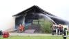 Update:Den Brand der Lagerhalle bei Niederrieden hatte ein Passant bemerkt. Er sah den Rauch von der Halle aus aufsteigen. Trotz sofortiger Verständigung der Feuerwehr stand die Halle, wie es im Polizeibericht heißt, kurze Zeit später in Vollbrand.
[video]https://www.youtube.com/watch?v=ewKGepygoV8[/video]Bagger helfen beim LöschenIn der Halle waren mehrere hundert Ballen Stroh und Heu gelagert. Um das Feuer zu löschen musste die Halle erst von zwei Baggern abgerissen werden. Danach wurde das Stroh und das Heu auf einem nahen Acker ausgebreitet und gelöscht. Die Arbeiten zogen sich bis in die Nacht hinein. Ursache noch unklarBei dem Einsatz waren Feuerwehren aus Niederrieden, Boos, Buxheim, Memmingen, Fellheim, Heimertingen, Reichau und Holzgünz sowie das THW Memmingen und der Rettungsdienst mit insgesamt etwa 150 Einsatzkräften im Einsatz. Es entstand ein Sachschaden von ca. 500.000 Euro. Das Fachkommissariat der Kriminalpolizei Memmingen hat vor Ort die Ermittlungen zum Brandfall übernommen. Die Brandursache ist derzeit noch unklar.Bezugsmeldung:Bei Niederrieden ist am Mittwochnachmittag eine Lagerhalle in Brand geraten. Beim Eintreffen der Einsatzkräfte stand die Halle bereits im Vollbrand. Die Feuerwehr ist mit mehreren Fahrzeugen und über 100 Einsatzkräften vor Ort. In dem Stadel waren laut Angaben unseres Reporters unter Anderem Heuballen und Brennholz gelagert.Hoher SachschadenDie Wasserversorgung soll sich schwierig gestalten, da die Schlauchleitung mehrere Hundert Meter lang ist. Mehrere Landwirte fahren deshalb mit Traktoren und Güllefässern Löschwasser zum Einsatzort. Weil sich auf dem Dach auch eine Photovoltaikanlage befand geht man aktuell von einem Sachschaden von mehreren hunderttausend Euro aus. Verletzt wurde nach aktuellem Stand niemand. Die Brandursache ist aktuell noch unklar.