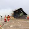 Update:Den Brand der Lagerhalle bei Niederrieden hatte ein Passant bemerkt. Er sah den Rauch von der Halle aus aufsteigen. Trotz sofortiger Verständigung der Feuerwehr stand die Halle, wie es im Polizeibericht heißt, kurze Zeit später in Vollbrand.
[video]https://www.youtube.com/watch?v=ewKGepygoV8[/video]Bagger helfen beim LöschenIn der Halle waren mehrere hundert Ballen Stroh und Heu gelagert. Um das Feuer zu löschen musste die Halle erst von zwei Baggern abgerissen werden. Danach wurde das Stroh und das Heu auf einem nahen Acker ausgebreitet und gelöscht. Die Arbeiten zogen sich bis in die Nacht hinein. Ursache noch unklarBei dem Einsatz waren Feuerwehren aus Niederrieden, Boos, Buxheim, Memmingen, Fellheim, Heimertingen, Reichau und Holzgünz sowie das THW Memmingen und der Rettungsdienst mit insgesamt etwa 150 Einsatzkräften im Einsatz. Es entstand ein Sachschaden von ca. 500.000 Euro. Das Fachkommissariat der Kriminalpolizei Memmingen hat vor Ort die Ermittlungen zum Brandfall übernommen. Die Brandursache ist derzeit noch unklar.Bezugsmeldung:Bei Niederrieden ist am Mittwochnachmittag eine Lagerhalle in Brand geraten. Beim Eintreffen der Einsatzkräfte stand die Halle bereits im Vollbrand. Die Feuerwehr ist mit mehreren Fahrzeugen und über 100 Einsatzkräften vor Ort. In dem Stadel waren laut Angaben unseres Reporters unter Anderem Heuballen und Brennholz gelagert.Hoher SachschadenDie Wasserversorgung soll sich schwierig gestalten, da die Schlauchleitung mehrere Hundert Meter lang ist. Mehrere Landwirte fahren deshalb mit Traktoren und Güllefässern Löschwasser zum Einsatzort. Weil sich auf dem Dach auch eine Photovoltaikanlage befand geht man aktuell von einem Sachschaden von mehreren hunderttausend Euro aus. Verletzt wurde nach aktuellem Stand niemand. Die Brandursache ist aktuell noch unklar.