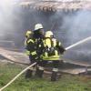 Update:Den Brand der Lagerhalle bei Niederrieden hatte ein Passant bemerkt. Er sah den Rauch von der Halle aus aufsteigen. Trotz sofortiger Verständigung der Feuerwehr stand die Halle, wie es im Polizeibericht heißt, kurze Zeit später in Vollbrand.
[video]https://www.youtube.com/watch?v=ewKGepygoV8[/video]Bagger helfen beim LöschenIn der Halle waren mehrere hundert Ballen Stroh und Heu gelagert. Um das Feuer zu löschen musste die Halle erst von zwei Baggern abgerissen werden. Danach wurde das Stroh und das Heu auf einem nahen Acker ausgebreitet und gelöscht. Die Arbeiten zogen sich bis in die Nacht hinein. Ursache noch unklarBei dem Einsatz waren Feuerwehren aus Niederrieden, Boos, Buxheim, Memmingen, Fellheim, Heimertingen, Reichau und Holzgünz sowie das THW Memmingen und der Rettungsdienst mit insgesamt etwa 150 Einsatzkräften im Einsatz. Es entstand ein Sachschaden von ca. 500.000 Euro. Das Fachkommissariat der Kriminalpolizei Memmingen hat vor Ort die Ermittlungen zum Brandfall übernommen. Die Brandursache ist derzeit noch unklar.Bezugsmeldung:Bei Niederrieden ist am Mittwochnachmittag eine Lagerhalle in Brand geraten. Beim Eintreffen der Einsatzkräfte stand die Halle bereits im Vollbrand. Die Feuerwehr ist mit mehreren Fahrzeugen und über 100 Einsatzkräften vor Ort. In dem Stadel waren laut Angaben unseres Reporters unter Anderem Heuballen und Brennholz gelagert.Hoher SachschadenDie Wasserversorgung soll sich schwierig gestalten, da die Schlauchleitung mehrere Hundert Meter lang ist. Mehrere Landwirte fahren deshalb mit Traktoren und Güllefässern Löschwasser zum Einsatzort. Weil sich auf dem Dach auch eine Photovoltaikanlage befand geht man aktuell von einem Sachschaden von mehreren hunderttausend Euro aus. Verletzt wurde nach aktuellem Stand niemand. Die Brandursache ist aktuell noch unklar.