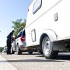 Polizeibeamte der Verkehrspolizeistationen Neu-Ulm und Memmingen und der Autobahnpolizei Memmingen haben am Donnerstagvormittag Wohnmobile und Wohnwagengespanne auf der A7 kontrolliert. Insgesamt hatten die Beamtinnen und Beamten während der rund 4,5-stündigen Kontrolle an der Raststätte "Allgäuer Tor" nur wenig zu beanstanden. 
Situation hat sich in den letzten Jahren deutlich verbessertDamit folgt die heutige Kontrolle dem Trend der letzten Jahren. Gab es vor über zehn Jahren noch regelmäßig Beanstandungen bei derartigen Kontrollen, so ist mittlerweile ein Großteil der Wohnmobil- und Wohnwagen-Fahrer sicher und im Rahmen der Vorschriften unterwegs. Laut Josef Gast, dem Dienststellenleiter der Autobahnpolizei Memmingen, liegt das einerseits an der intensiven Präventionsarbeit der Polizei in Bayern, andererseits aber auch an der technischen Entwicklung der modernen Wohnmobile und Wohnwägen. Im Vergleich zu älteren Modellen ist zum Beispiel die Zuladekapazität moderner Fahrzeuge oftmals deutlich höher, als das noch vor einigen Jahren der Fall war.Gesamtgewicht immer seltener ein ProblemInsgesamt ist ein überschrittenes Gesamtgewicht der Reisemobile und Wohnwagen-Gespanne immer seltener ein Grund für Beanstandungen durch die Polizei, so Josef Gast. Viel eher hakt es da - besonders bei Wohnwagen-Gespannen - an anderen Faktoren: Auf die Stützlast achten: Nicht alle Gespannfahrer haben die zulässige Stützlast - also das Gewicht, das auf die Anhängerkupplung des Zugfahrzeugs wirkt - im Blick. Gerade hier stellen die Beamtinnen und Beamten immer wieder Verstöße fest. Ein voller Wassertank, schwere Gasflaschen und dann noch E-Bikes auf der Deichsel des Wohnwagens und schon ist die zulässige Stützlast schnell überschritten. Liegt die 20 Prozent über dem zulässigen Wert, muss die Polizei eine Weiterfahrt unterbinden. Dann hilft nur: Abladen und mit weniger Last weiterfahren.Ladungssicherung nicht vergessen: Ein weiteres Problem - die Ladungssicherung. Wie bei Transportern, LKW und anderen Anhängern gilt auch bei der Fahrt in den Urlaub: Die Ladung in Wohnwagen und Wohnmobil muss der Fahrer ordentlich sichern und verstauen. Auch hier stellt die Polizei bei Kontrollen immer wieder Mängel fest. Die richtigen Reifen am Wohnwagen und genügend Übung: Neben Ladungssicherung, Stützlast und Gesamtgewicht achten die Beamten natürlich auch auf weitere Faktoren. Ein Beispiel: Bei Wohnwägen mit einer 100 km/h-Zulassung auf Autobahnen spielen die Reifen des Anhängers eine entscheidende Rolle. Diese müssen nicht nur für 120 km/h ausgelegt sein, sondern dürfen auch ein bestimmtes Alter nicht überschreiten. Spätestens nach sechs Jahren müssen auf den Anhänger nämlich neue Reifen drauf, sonst erlischt automatisch die 100 km/h-Zulassung und es darf nur noch mit maximal 80 km/h gefahren werden.Grundsätzlicher Tipp des Polizisten: Fahrsicherheitstraining mit Anhänger oder WohnmobilAbseits von Gewichtsgrenzen, Reifenalter und Ladungssicherung rät Josef Gast allen Wohnmobil- und Wohnwagen-Fahrern zu einer angepassten Fahrweise und regelmäßigen Sicherheitstrainings. Gerade wenn man nur ein paar Mal im Jahr mit Reisemobil und Wohnwagen unterwegs ist, bringt regelmäßige Übung ein großes Plus an Sicherheit. Allerdings - und darauf legt der Chef der Memminger Autobahnpolizei Wert - gilt das auch für alle anderen Fahrzeuge.
