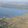 Das Ammersee-Südufer von Südwesten: Erkennbar sind (von links) die weit im See liegende Mündung der Alten Ammer, das Erlaich (“Schwedeninsel“), der Fischener Wasen und der Kanal der Neuen Ammer im Fischener Winkel.