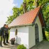 Daniel Käß (links) und Günter Lichtblau von der Verwaltung begutachten die frisch renovierte Kapelle. Die Linde hat kaum an Schönheit verloren. 