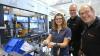 Anlagenführerin Rosali Maurer mit den beiden Werkleitern Jochen Kärcher (Mitte) und Johannes Lauterbach bei der Montage des neuen IPB – eines Bremskraftverstärkers samt Anti-Blockiersystem und Stabilitäts-Programm.