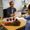 Peter Kloos, Leiter der Abteilung Arbeit und Soziales bei der Stadt Kaufbeuren, überreicht einen der Gutscheine.
