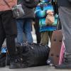 Flüchtlinge aus der Ukraine stehen mit Gepäck am Münchner Hauptbahnhof nach ihrer Ankunft.