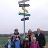 Jürgen Häußler, Lena Zimmermann (Hortleitung) und Erwin Haider posieren zusammen mit Kindern vom Kinderhort Münsterhausen vor dem neuen internationalen Wegweiser in Münsterhausen.