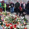 Menschen legen Blumen und Kerzen am offiziellen Gedenkort nach Todesfahrt auf Weihnachtsmarkt in Magdeburg an der Johanniskirche nieder.