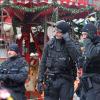 Einsatzkräfte der Polizei stehen auf dem Weihnachtsmarkt in Magdeburg vor einem Karussell.